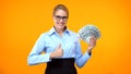 Beautiful business woman showing thumbs up holding money, well paid job, income