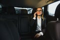 Beautiful business woman sitting on back seat in the car Royalty Free Stock Photo