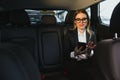 Beautiful business woman sitting on back seat in the car Royalty Free Stock Photo