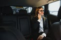 Beautiful business woman sitting on back seat in the car Royalty Free Stock Photo