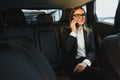 Beautiful business woman sitting on back seat in the car Royalty Free Stock Photo