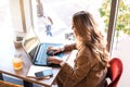 Beautiful business woman sitting in cafe and taking notes in notebook. Royalty Free Stock Photo