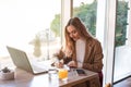 Beautiful business woman sitting in cafe and taking notes in notebook. Royalty Free Stock Photo