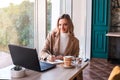 Beautiful business woman sitting in cafe and taking notes in notebook. Royalty Free Stock Photo