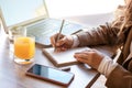 Beautiful business woman sitting in cafe and taking notes in notebook. Royalty Free Stock Photo