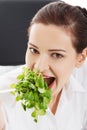 Beautiful business woman sitting and eating lettuce. Royalty Free Stock Photo