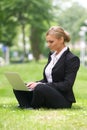 Beautiful business woman sitting with laptop in park Royalty Free Stock Photo