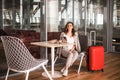 Beautiful business woman with smartphone waiting for her flight in an airport. Royalty Free Stock Photo