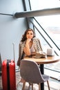 Beautiful business woman with smartphone waiting for her flight in an airport. Royalty Free Stock Photo