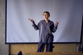 beautiful business woman speaking at a meeting in front of a large projector screen Royalty Free Stock Photo