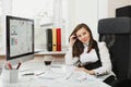 Beautiful business woman in suit and glasses working at computer with documents in light office Royalty Free Stock Photo