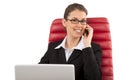 Beautiful business woman talking on mobile phone sitting on a red chair in office Royalty Free Stock Photo