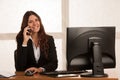 Beautiful business woman talks on the smart phone at desk in her