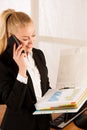 Beautiful business woman talks on a smart phone in her office at Royalty Free Stock Photo