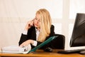 Beautiful business woman talks on a smart phone in her office at Royalty Free Stock Photo