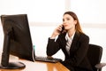 Beautiful business woman talks on smert phone in office at her desk Royalty Free Stock Photo