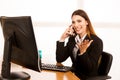 Beautiful business woman talks on smert phone in office at her desk Royalty Free Stock Photo