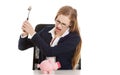 Beautiful business woman is trying to destroy piggy bank with ha Royalty Free Stock Photo