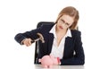 Beautiful business woman is trying to destroy piggy bank with ha Royalty Free Stock Photo