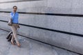 Beautiful business woman using mobile phone and pulling her suitcase. Caucasian female traveler with suitcase at airport Royalty Free Stock Photo