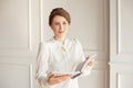 Beautiful business woman in a white shirt and dark pants holding a folder with documents. Royalty Free Stock Photo