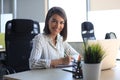 Beautiful business woman is writing something down while sitting in the office desk Royalty Free Stock Photo