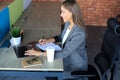 Beautiful business woman is writing something down while sitting in the office desk Royalty Free Stock Photo