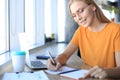 Beautiful business woman is writing something down while sitting in the office desk Royalty Free Stock Photo