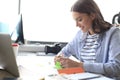 Beautiful business woman is writing something down while sitting in the office desk Royalty Free Stock Photo