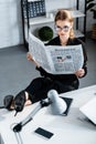 Beautiful businesswoman in black clothes and shoes sitting at table and