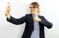 Beautiful businesswoman with eyeglasses and elegantly dressed on isolated white background smiling in video call on smartphone mak Royalty Free Stock Photo