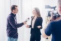 Beautiful businesswoman in formal wear giving interview to journalist and gesturing Royalty Free Stock Photo