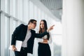 Beautiful businesswoman listening to her colleague at the meeting about changes panoramic office. Business man pointed with hands Royalty Free Stock Photo