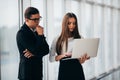 Beautiful businesswoman listening to her colleague at the meeting about changes panoramic office. Business man pointed with hands Royalty Free Stock Photo