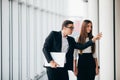 Beautiful businesswoman listening to her colleague at the meeting about changes panoramic office. Business man pointed with hands Royalty Free Stock Photo