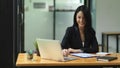 Beautiful businesswoman looking, checking, working on laptop with smile face Royalty Free Stock Photo