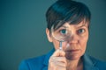 Beautiful businesswoman looking through magnifying glass