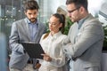 Beautiful businesswoman with male colleagues discussing about work in an office. Royalty Free Stock Photo