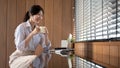 A beautiful businesswoman is reading online documents on her laptop and having her morning coffee Royalty Free Stock Photo