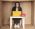 Beautiful businesswoman sits in tight paper office, smile on face