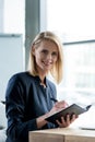 beautiful businesswoman smiling at camera while taking notes Royalty Free Stock Photo