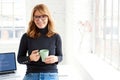 Beautiful businesswoman standing in the office while drinking her coffee Royalty Free Stock Photo