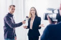 Beautiful businesswoman in suit giving interview to journalist and gesturing