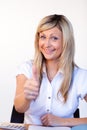 Beautiful businesswoman with thumbs up in office Royalty Free Stock Photo