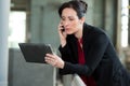 Beautiful businesswoman using digital tablet at office railing