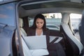 Beautiful businesswoman using laptop while sitting on back seat in the car while working online. Business, people Royalty Free Stock Photo