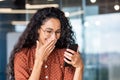 Beautiful businesswoman using phone at workplace, successful and joyful latin american woman typing text message using Royalty Free Stock Photo