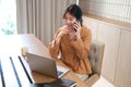 Beautiful businesswoman using a smartphone and working with a laptop while sitting at an office desk, working from home concept Royalty Free Stock Photo