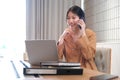 Beautiful businesswoman using a smartphone and working with a laptop while sitting at an office desk, working from home concept Royalty Free Stock Photo