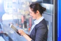 Beautiful businesswoman using a tablet, in front of windows in o Royalty Free Stock Photo